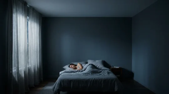 Person sleeping peacefully in darkened bedroom with serene atmosphere representing deep sleep restoration
