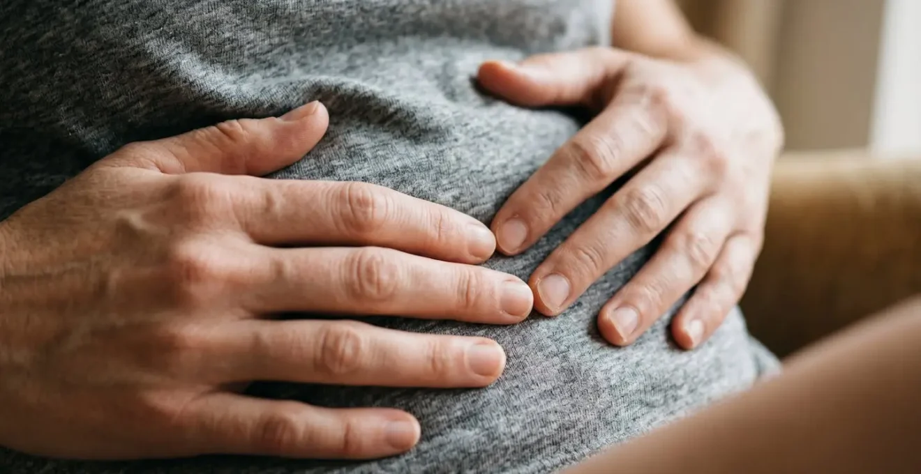 Macro detail of hands resting on abdomen showing tactile awareness and interoceptive focus