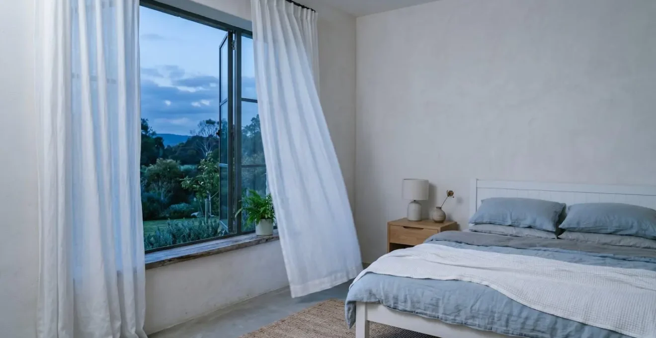 Minimalist bedroom interior showing natural cooling elements and serene sleep environment